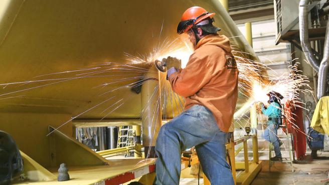 Sparks fly as A.J. Herder and Randy Sistad, both fabricator / welders at TriTec, use grinders to fix a water tank used in the Highway 53 bridge project near Virginia on Tuesday. Photo by Bob King.